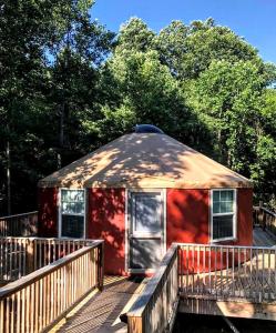 a large red building with a wooden deck at Intimate Yurt Rental Ideal for Romantic Glamping in Virginia in Rich Creek