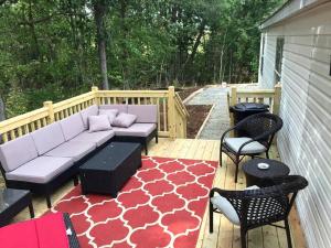 a patio with a couch and chairs on a deck at Spacious Modular Rental on Huge Horse and Cattle Farm near Charlottesville, Virginia in Gordonsville