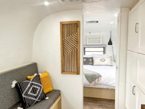 a small bedroom with a bed and a mirror at Colorado Caravan Experience: Airstream Adventure Under the Stars in Grand Junction in Grand Junction