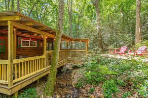 a cabin in the woods with two chairs and a porch at Creekfront Cabin Amazing for Families in Helen, Georgia in Helen