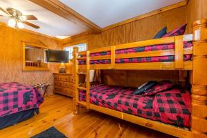 a bedroom with two bunk beds and a tv at Creekfront Cabin Amazing for Families in Helen, Georgia in Helen +17 photos