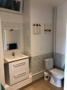 Un baño con inodoro, lavabo y espejo. en Small country house,  5 fotos más