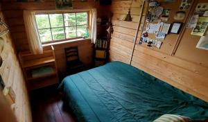 una camera da letto con un letto in una stanza con una finestra di Eco-Friendly Peaceful Cabin with Lofted Interior and Water Views in Maine a Steuben