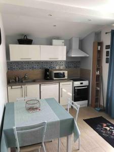 y cocina con mesa, sillas y fogones. en Small country house, 