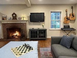 a living room with a chess board in front of a fireplace at Unique Ski Rental in Berkshires Charlemont Near Hawley State Forest, Plainfield, Western Massachusetts in Plainfield +61 photos