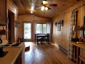 a kitchen and dining room of a log cabin at Idyllic Lake Cabin for a Camping Getaway in Cross Wing County, Minnesota in Emily