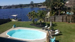 a swimming pool next to a body of water at Beautiful Waterfront Cottage Rental with a Pool near New Orleans, Louisiana in Slidell