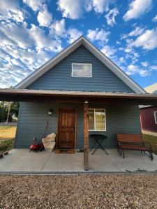 a blue house with a porch and a bench at Brand New, Modern Country Cabin near Bryce Canyon National Park, Utah in Cannonville