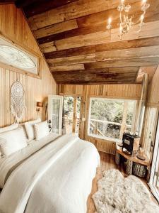 a bedroom with a large bed in a room with wooden walls at Stunning Pet-Friendly Treehouse for Relaxing Glamping Retreats in North Carolina in Retreat