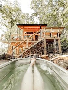 a person in a swimming pool in front of a house at Stunning Pet-Friendly Treehouse for Relaxing Glamping Retreats in North Carolina in Retreat