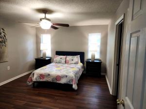 ein Schlafzimmer mit einem Bett und einem Deckenventilator in der Unterkunft Quaint Cottage with Covered Dock on the Pond and Walking Trails in Georgia in Midway