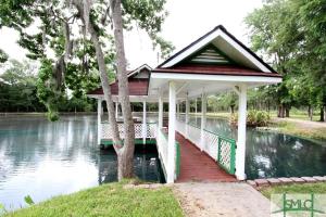 einen Pavillon inmitten eines Teiches in der Unterkunft Quaint Cottage with Covered Dock on the Pond and Walking Trails in Georgia in Midway