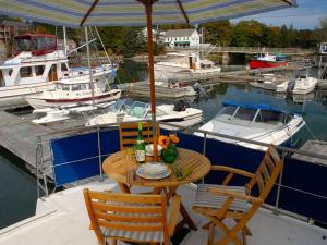 a table and chairs on a boat in a marina at Unique Yacht Rental in a Peaceful Setting on Damariscotta River, Maine in Newcastle
