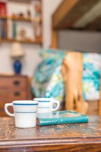 two cups sitting on a table in a living room at Rustic Cabin Rental Perfect for Families in Texas Hill County in Marble Falls