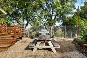 a picnic table in a backyard with a fence at Inspiring Cottage Rental for a Vacation in California Wine Country in Lockeford