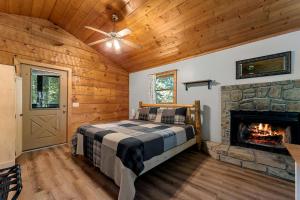 a bedroom with a bed and a fireplace at Charming Cabin with Spa and Mountain Views in Sevierville, Tennessee in Pinnacle