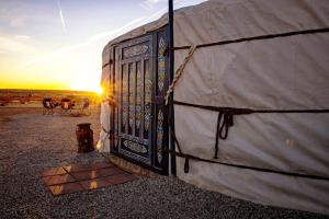 a door of a tent with the sunset in the background at Family-Friendly Yurt for Stargazing near Joshua Tree National Park, California in Sunfair Heights