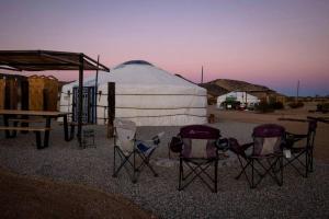 a group of chairs and a tent in the desert at Family-Friendly Yurt for Stargazing near Joshua Tree National Park, California in Sunfair Heights