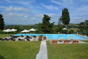 a swimming pool with chairs and umbrellas in a yard at Villa San Filippo in Barberino di Val dʼElsa