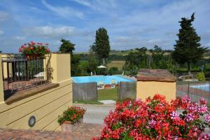 a view of a pool from a garden with flowers at Villa San Filippo in Barberino di Val dʼElsa