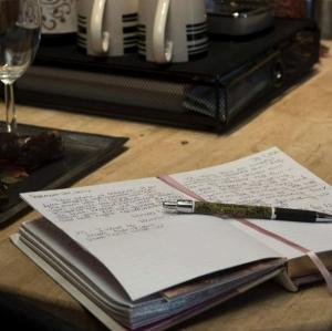 a pen sitting on top of a book on a table at Romantic Glamping Getaway with a Shared Hot Tub and Hiking Trails near Nashville, Tennessee in Gordonsville