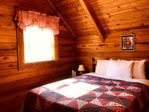 une chambre avec un lit dans une cabane en rondins dans l'établissement Secluded Cabin Rental near Watoga State Park in West Virginia, à Hico