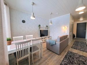 comedor y sala de estar con mesa y sofá en Aurinkotuuli C9, en Kalajoki