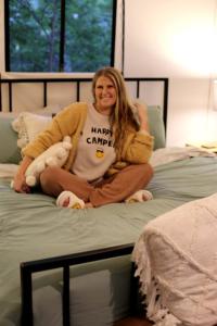 uma mulher sentada em cima de uma cama em Stunning Tented Cabin with Fire Pit in Des Moines, Iowa em Marquisville