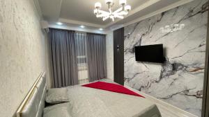 TV a/nebo společenská místnost v ubytování ЖК Prime Park, сердце отдыха рядом с памятником Байдибек би, Зоопарком, Дендропарком, Shymkent Mall и парк музыкальным фонтаном Shymkent City