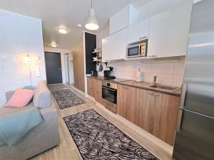 una pequeña cocina con sofá y fregadero en Aurinkotuuli C9, en Kalajoki 4 fotos más