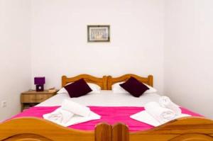1 dormitorio con 1 cama grande con sábanas rosas y blancas en Apartment Sara en Dubrovnik