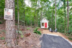 a tiny house in the woods with a sign at Picturesque Tiny Cabin Surrounded by Nature in Alabama in Grant
