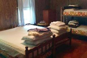 un lit avec une pile de couvertures et d'oreillers dessus dans l'établissement Spacious Cottage Rental with a Fire Pit and Fabulous Views in Summit Lake, Wisconsin, à Summit Lake