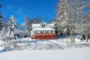 une maison dans la neige avec des arbres enneigés dans l'établissement Spacious Cottage Rental with a Fire Pit and Fabulous Views in Summit Lake, Wisconsin, à Summit Lake