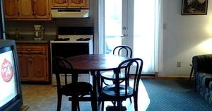 a kitchen with a table and chairs and a television at Spacious Cabin Rental next to Balsam Mountain in Upstate New York in Big Indian