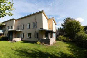 a house with a grass yard in front of it at Newly renovated large family apartment, parking, sauna, balcony in Jyväskylä