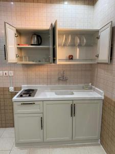 a kitchen with white cabinets and a sink at شقق دفادف المخدومة in Hail