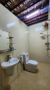 a bathroom with a toilet and a sink at Bait Aljabal Hospitality Inn in Al Ḩamrāʼ
