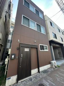 a brown building with a door on the side of it at Rest Collection SEIWA LODGE Tokyo in Tokyo