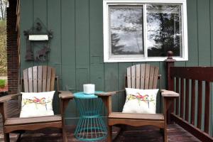 two chairs sitting on a porch with a table at Your Perfect Getaway: Mountain Cabin Retreat with Hot Tub and Fireplace in Lisbon, NH in Lisbon +14 photos