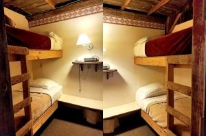 Ce lit se trouve dans un dortoir doté de 2 lits superposés et d'une lampe. dans l'établissement Rustic Barn Rental for a Rural Vacation near Des Moines, Iowa, à Montezuma