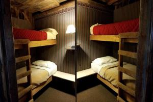 une chambre avec trois lits superposés dans une cabine dans l'établissement Rustic Barn Rental for a Rural Vacation near Des Moines, Iowa, à Montezuma 7 autres photos