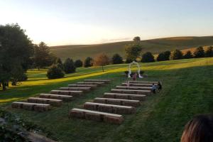 eine Gruppe von Menschen, die auf einem Grasfeld stehen in der Unterkunft Rustic Barn Rental for a Rural Vacation near Des Moines, Iowa in Montezuma