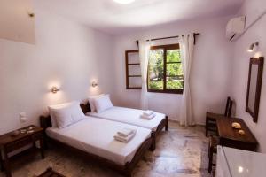 Postel nebo postele na pokoji v ubytování Naftilos Skiathos