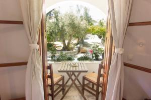 a room with a table and chairs and a window at Naftilos Skiathos in Skiathos