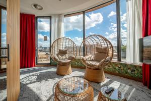 two chairs and a table in a room with windows at Van Der Valk Sélys Liège Hotel & Spa in Liège