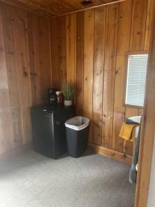 baño con cubo de basura en una pared de madera en Cozy Tiny Cabin 8 in Rapid City, SD, en Hill City