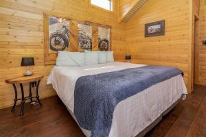 a bedroom with a bed in a log cabin at Log Cabin Rentals near San Antonio, Texas, Perfect for Weekend Glamping near Austin in Pipe Creek