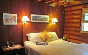 ein Schlafzimmer mit einem Bett mit zwei Lampen in der Unterkunft Lovely Log Cabin with Spectacular Mountain Views in Brandon, Vermont in Pittsford
