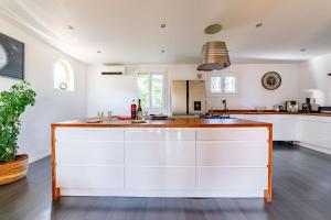 a kitchen with white cabinets and a large island at Apartment with pool and garden in Taradeau